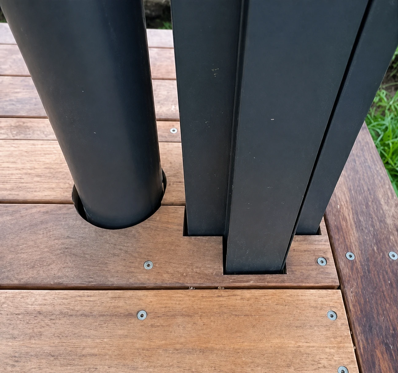 Close-up of neatly fitted deck boards around black posts